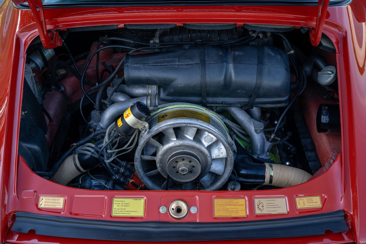 Red 1974 Porsche 911 Carrera Targa flat-six engine with fan and intake system.