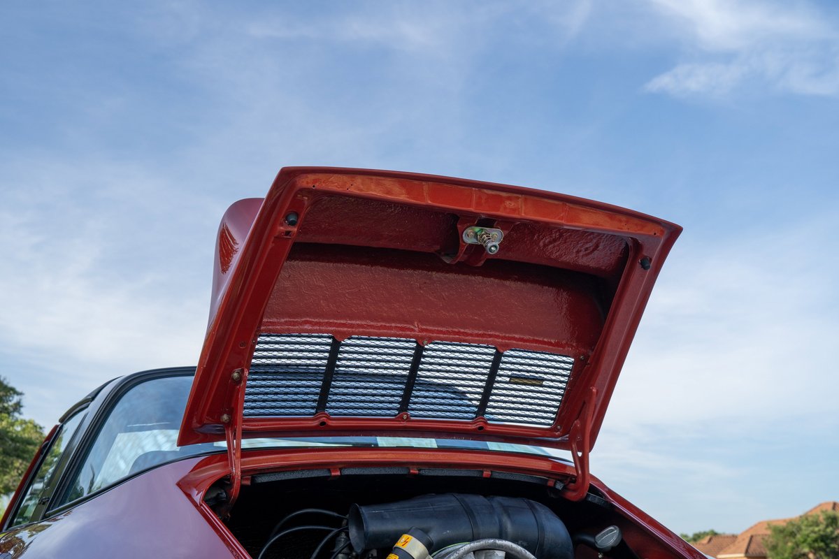 Red 1974 Porsche 911 Carrera Targa engine compartment with hood open.