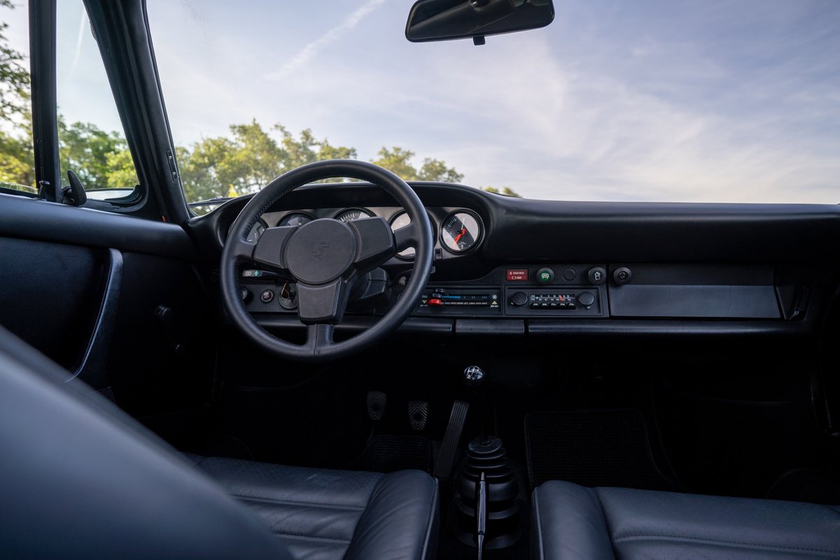 1974 Porsche 911 Carrera Targa interior. Black leather seats, dashboard, and steering wheel.