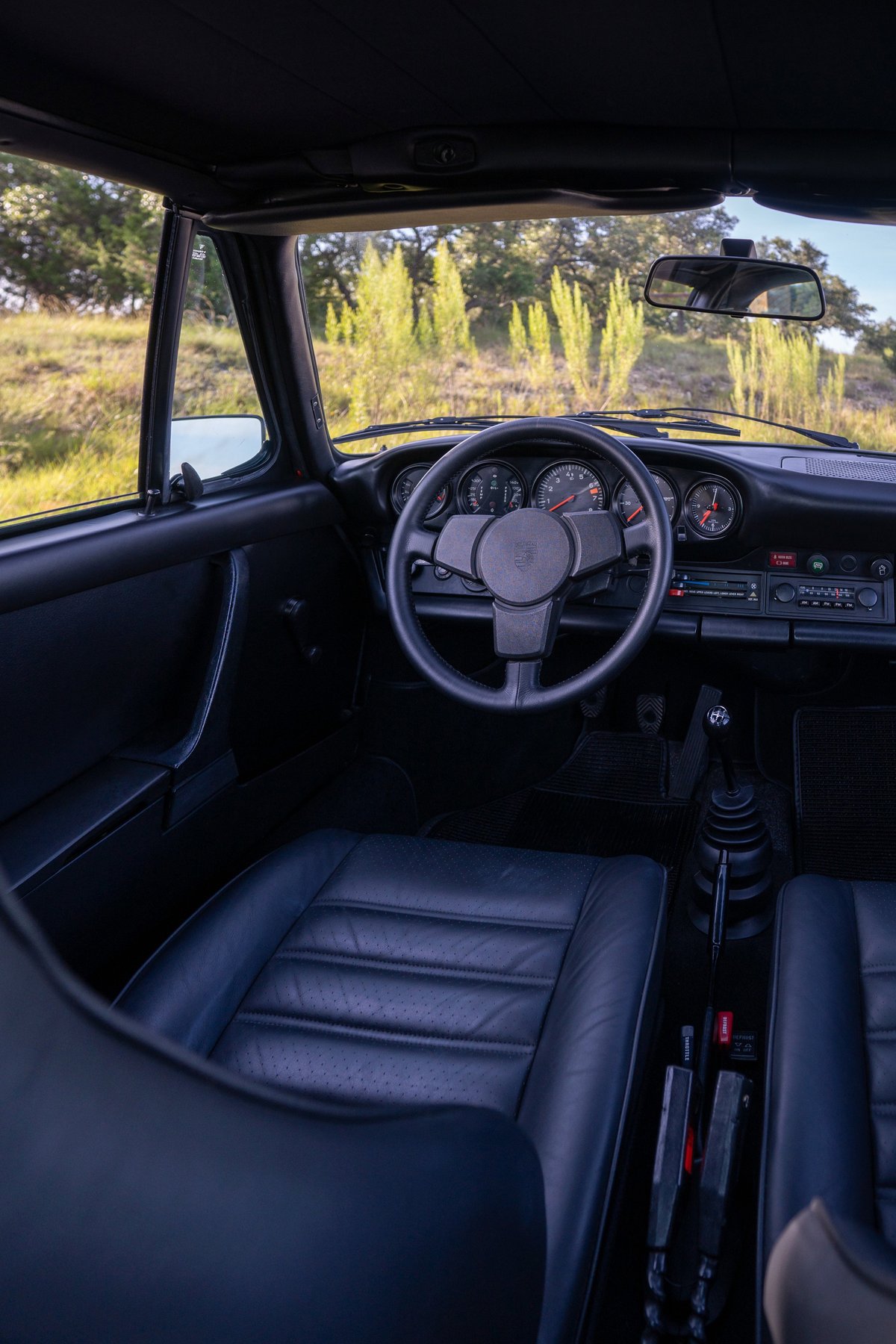 1974 Porsche 911 Carrera Targa interior with black leather seats and dashboard.