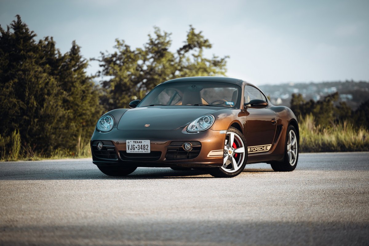 Brown 2008 Porsche Cayman S with silver rims and "PORSCHE" livery.