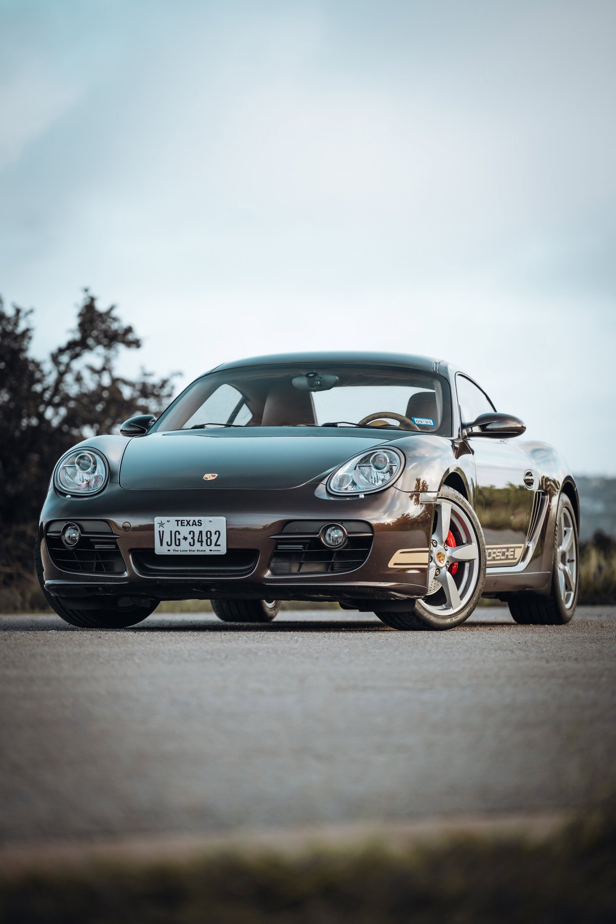 Front 3/4 view of a macadamia metallic 2008 Porsche Cayman S, with silver alloy rims and red brake calipers.