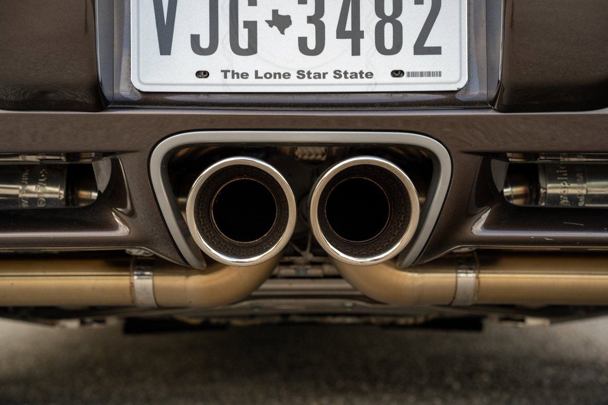 Rear view of a Macadamia Metallic 2008 Porsche Cayman S with quad exhaust tips.