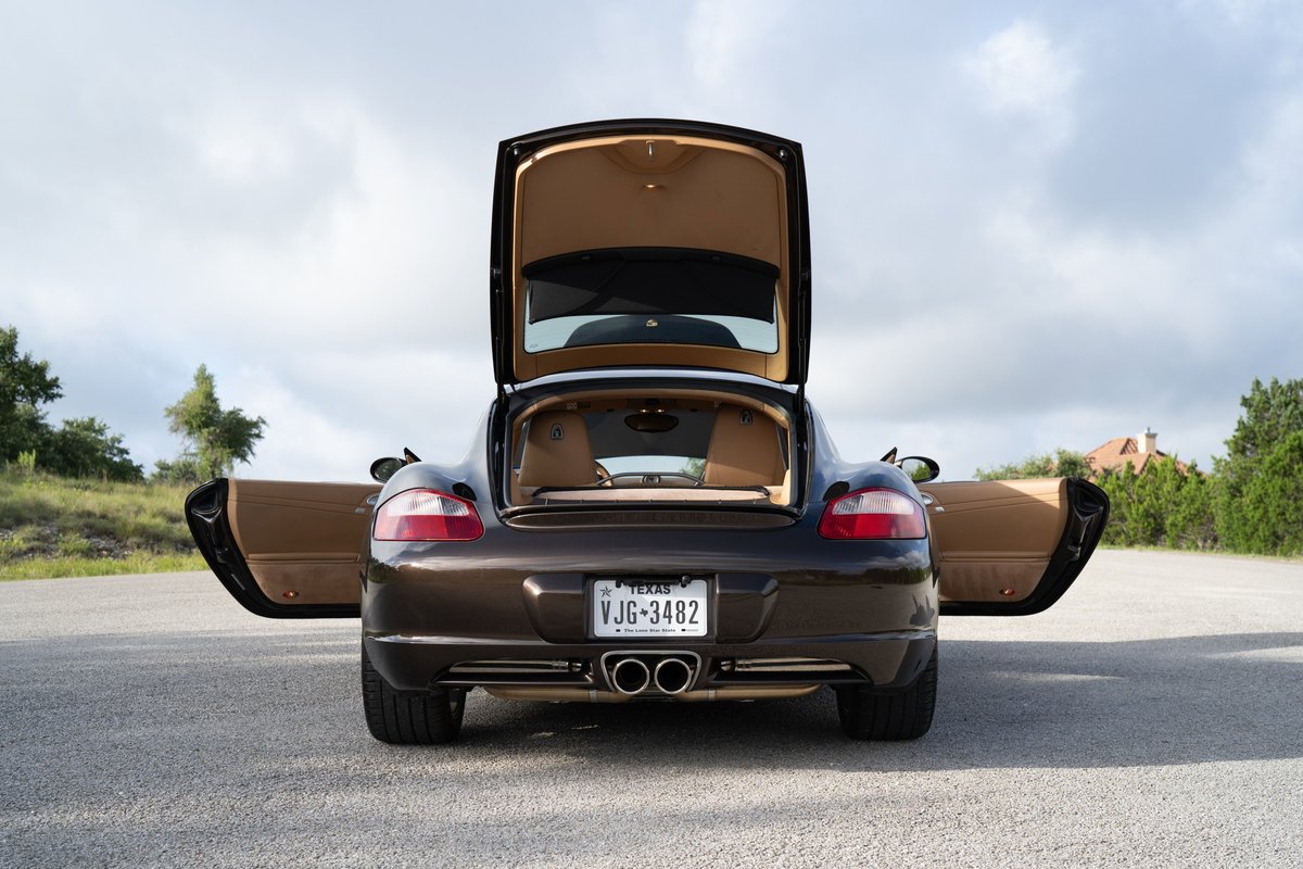 Macadamia Metallic 2008 Porsche Cayman S with open doors and trunk.