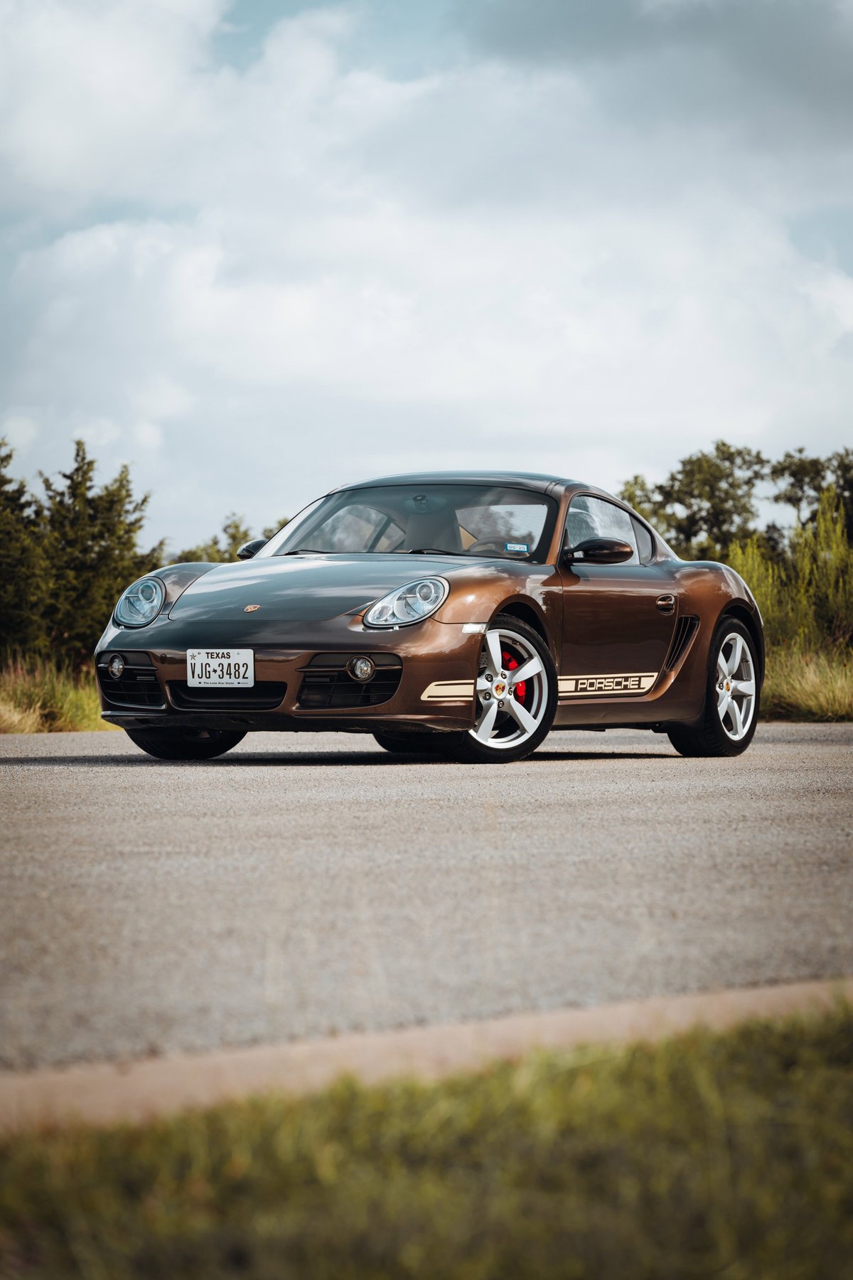Front 3/4 view of a Macadamia Metallic 2008 Porsche Cayman S with unique side livery and red brake calipers.