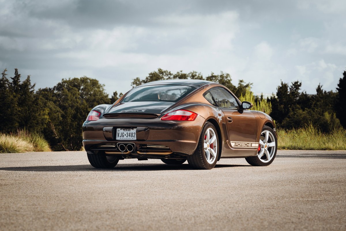 Brown 2008 Porsche Cayman S with distinctive "Porsche" livery on the rocker panels and silver alloy rims.