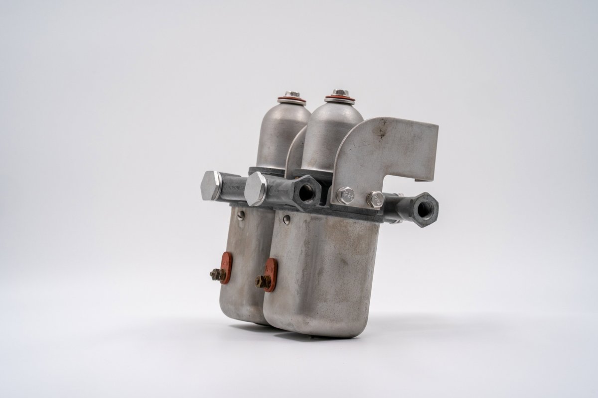 Vintage Porsche 550 Spyder fuel filter assembly, raw metal finish.