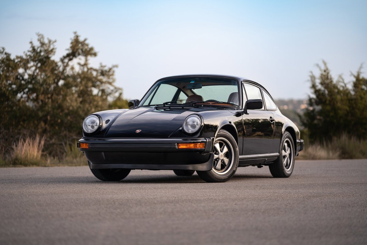 Black 1976 Porsche 911S Sportomatic with Fuchs rims and chrome trim.