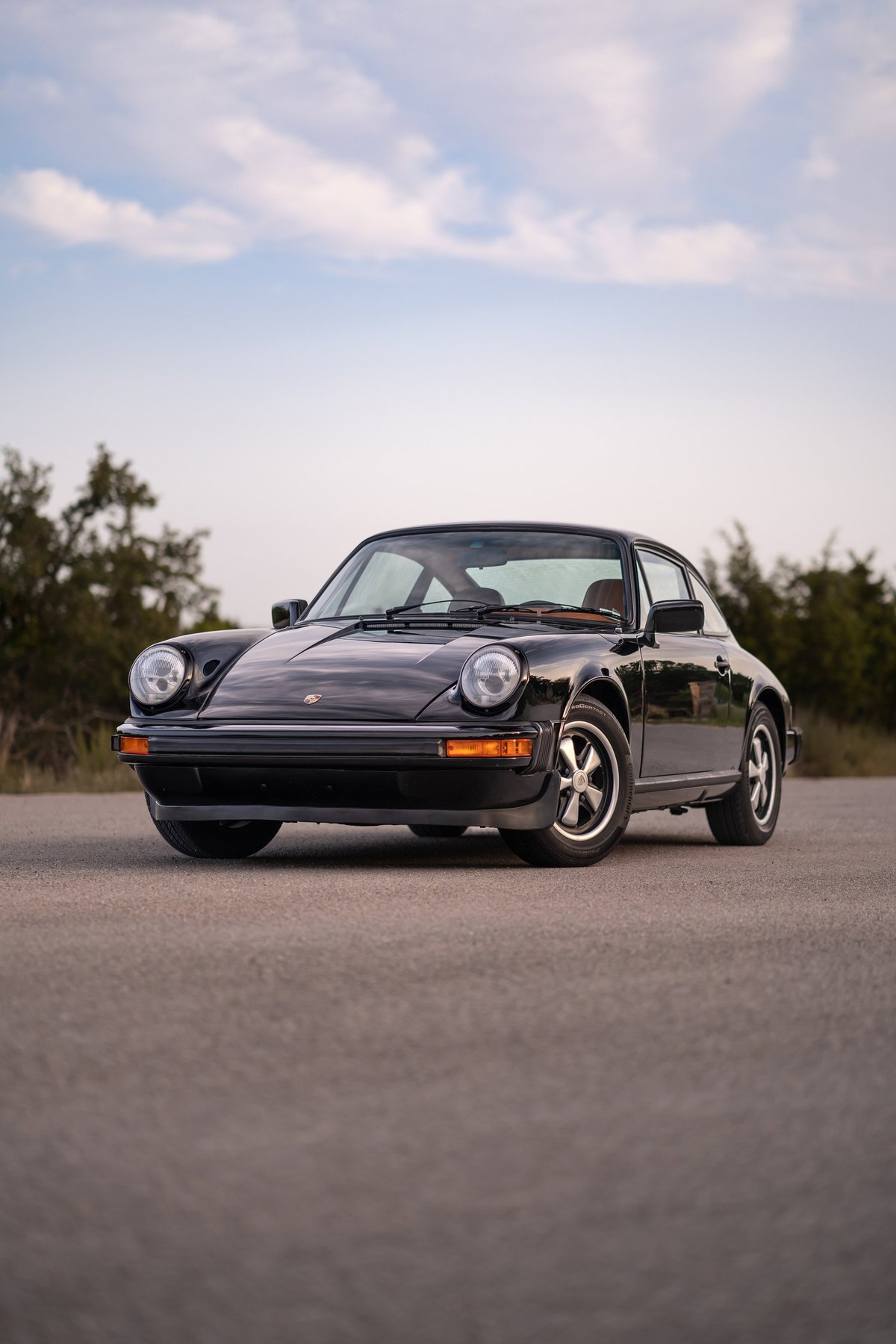 Black 1976 Porsche 911S Sportomatic with Fuchs wheels and chrome trim.