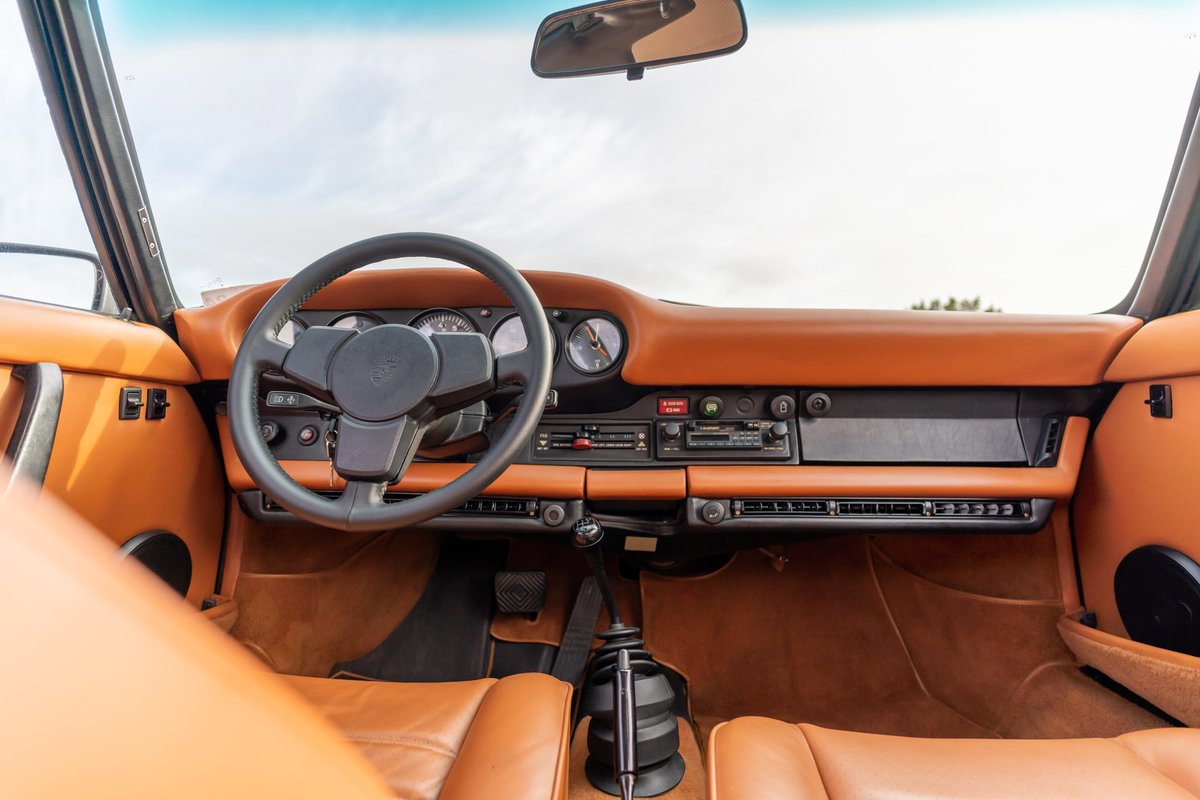 Interior of a black 1976 Porsche 911S with tan leather trim and a Sportomatic transmission.