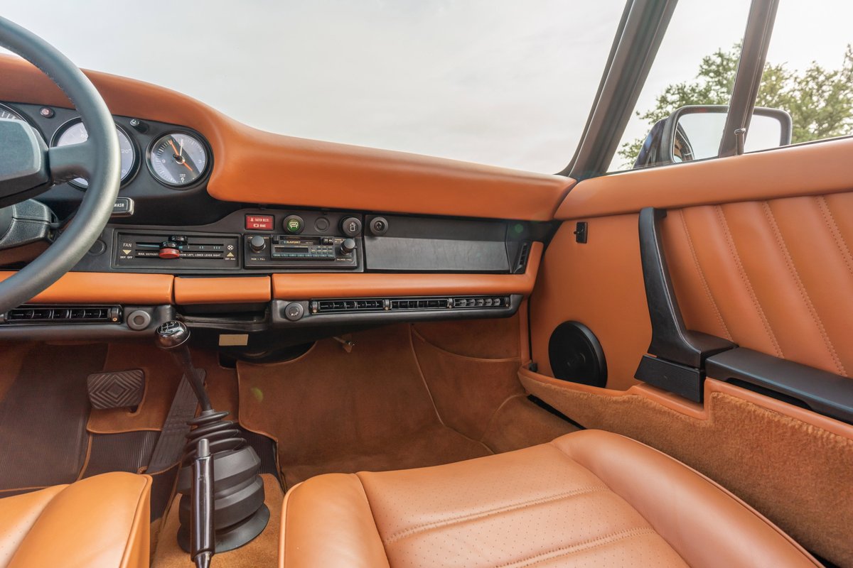 1976 Porsche 911 S Sportomatic interior. Tan leather seats, dashboard and door trim. Black steering wheel and shift knob.
