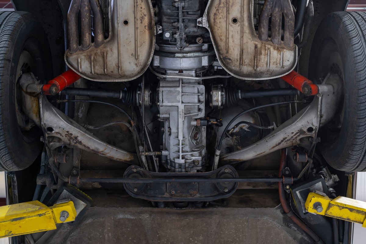 Underside view of a black 1976 Porsche 911S Sportomatic showing drivetrain and suspension.