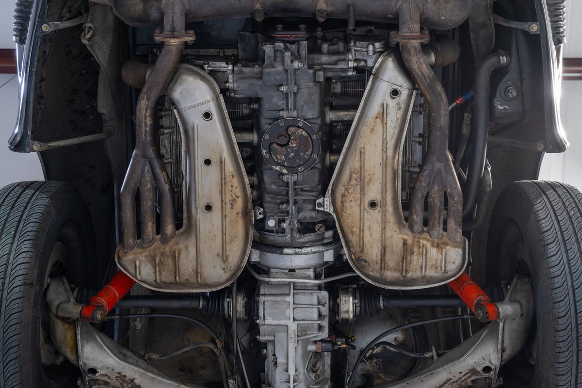 Underneath view of a black 1976 Porsche 911S Sportomatic, showing engine and exhaust.