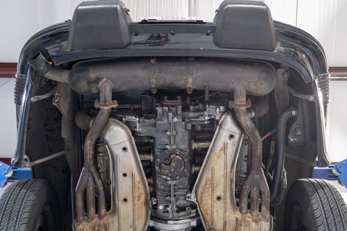 Underneath view of a black 1976 Porsche 911S Sportomatic showing engine and exhaust system.