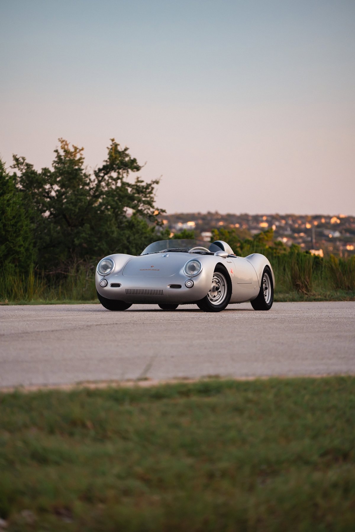 Silver Beck 550 Spyder convertible on a road, showing chrome rims and classic racing trim.