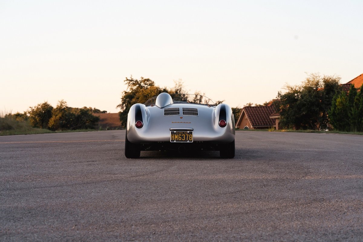 Rear view of a silver Beck 550 Spyder with gold California plates.