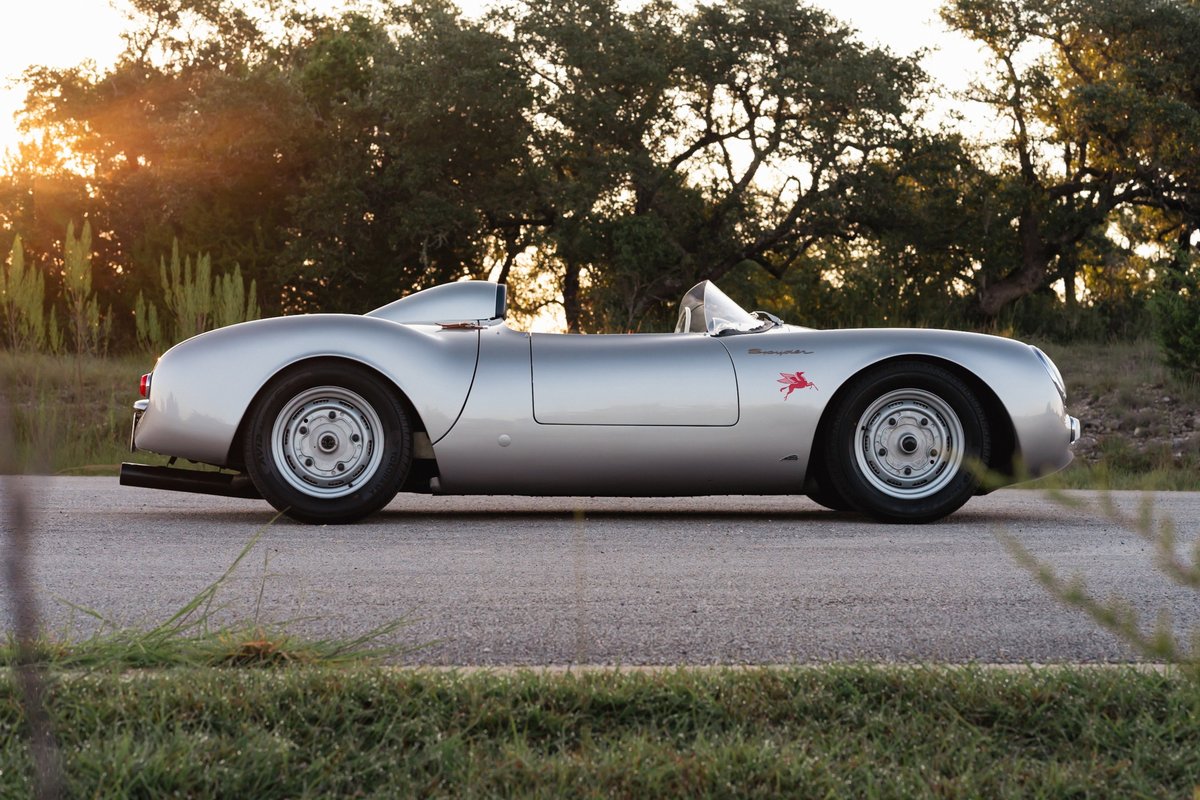 Silver Beck 550 Spyder with red emblem, sitting on a paved road at sunset.