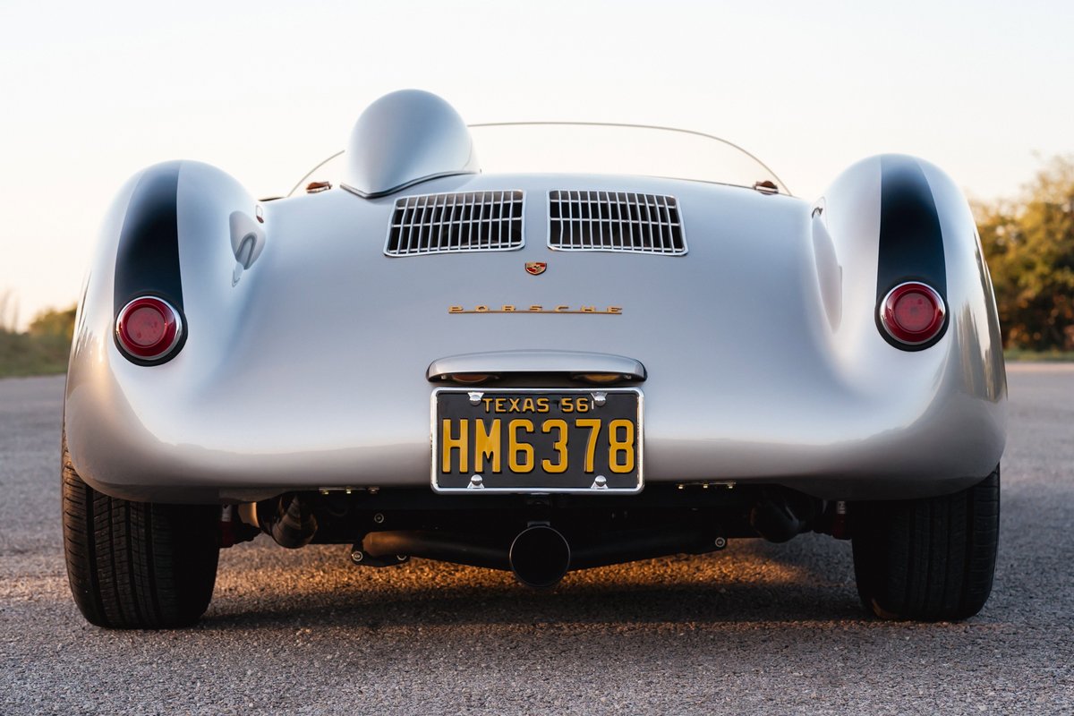 Rear view of a silver Beck 550 Spyder with black stripe livery on fenders and classic license plate.