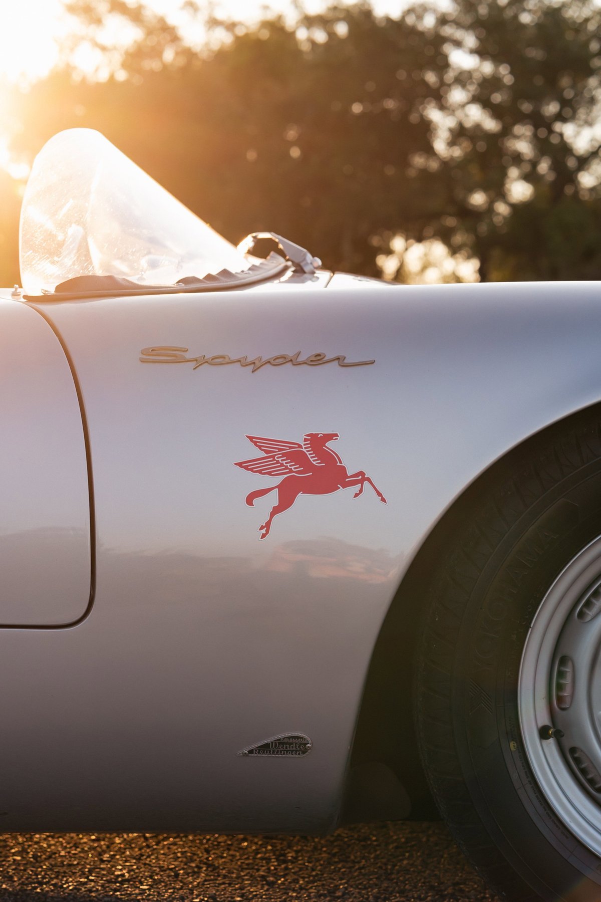 Silver Beck 550 Spyder with red Pegasus livery and chrome rims, bathed in golden hour light.