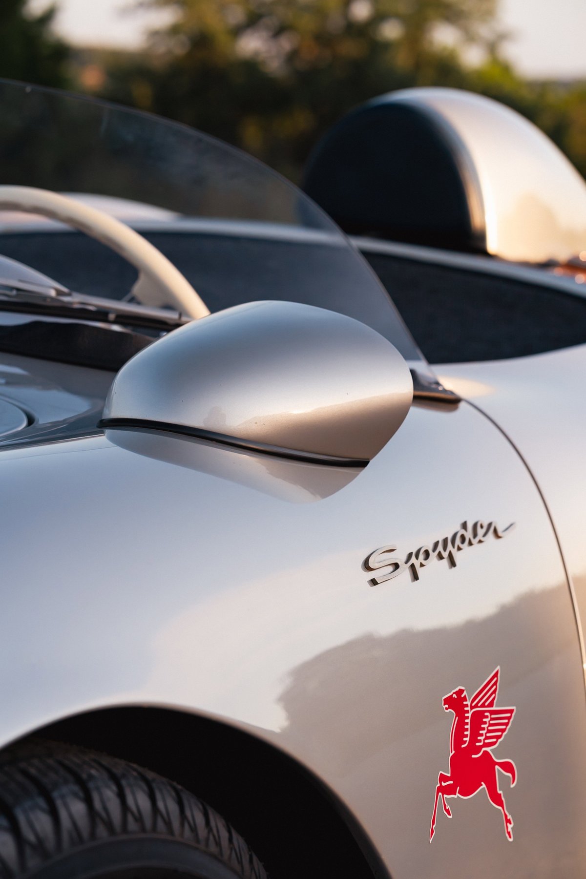 Silver Beck 550 Spyder with black trim, red Pegasus emblem, and wire wheels.