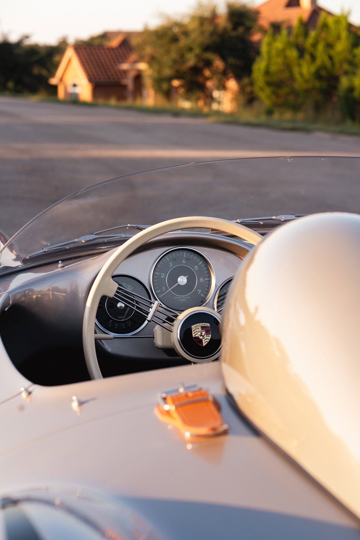 Close-up of the beige steering wheel and instrument cluster of a Beck 550 Spyder, with a blurred background.