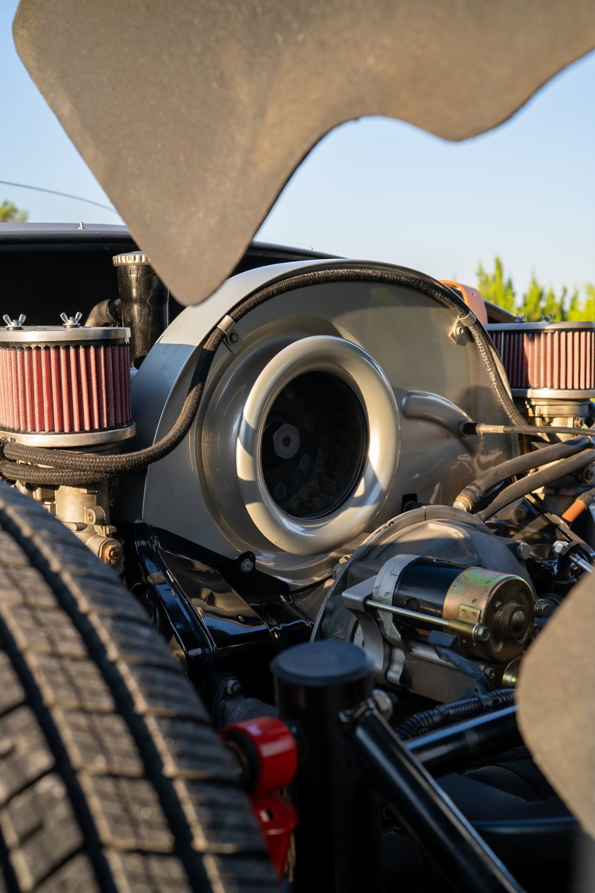 Close-up of the rear-mounted engine of a silver Beck 550 Spyder, showing air intake and fan shroud.