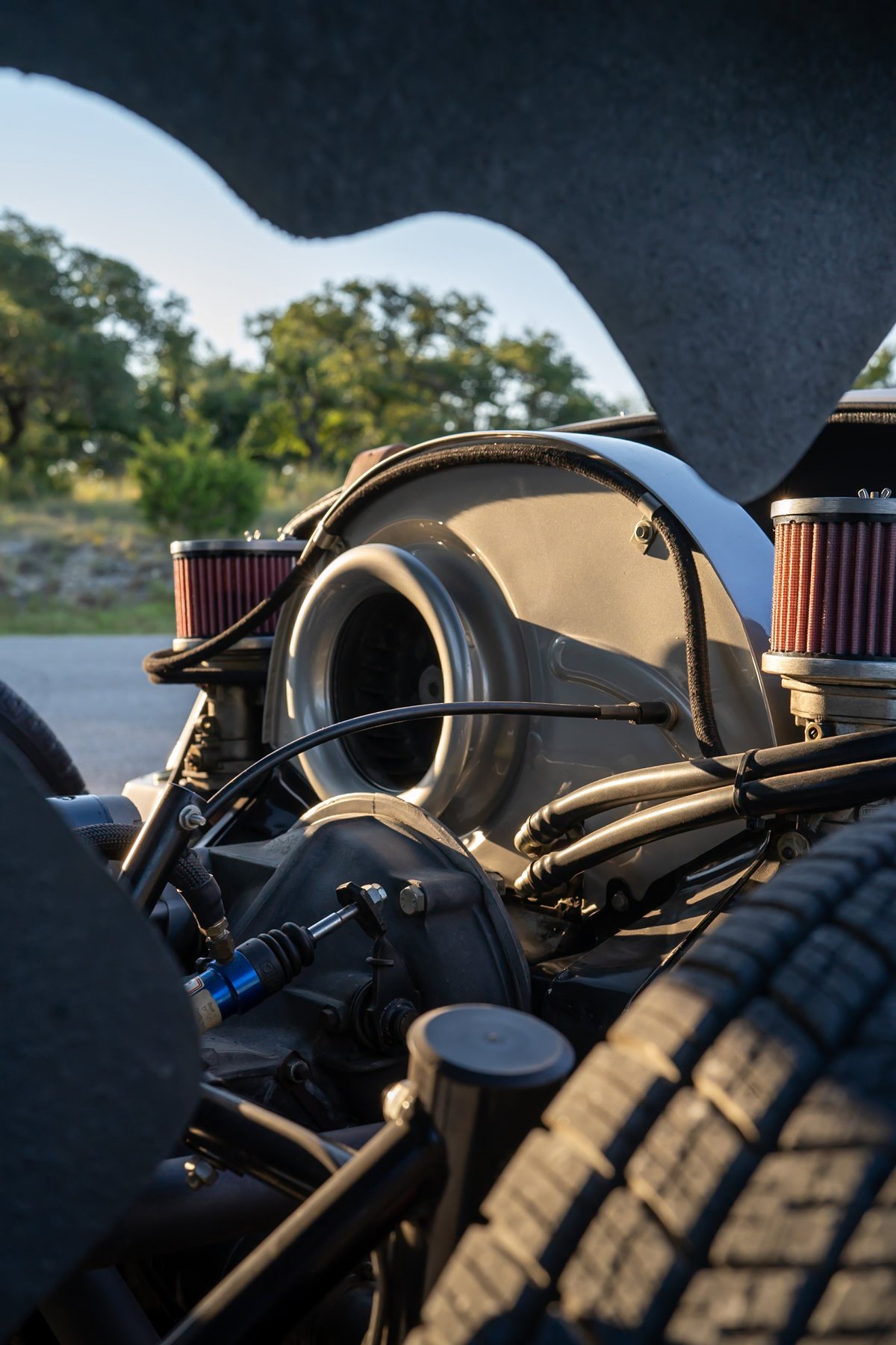 Close-up of a Beck 550 Spyder engine with twin air filters and chrome exhaust pipes.