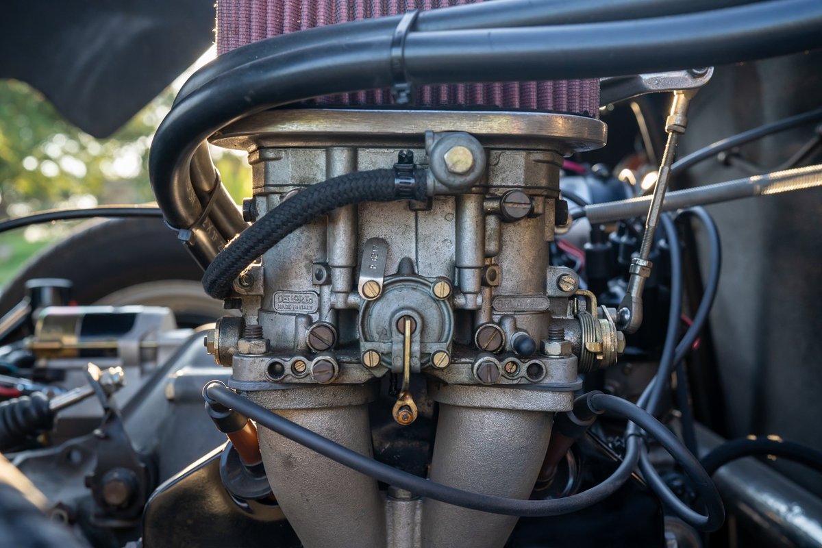 Close-up of a vintage Beck 550 Spyder dual Weber carburetor setup.