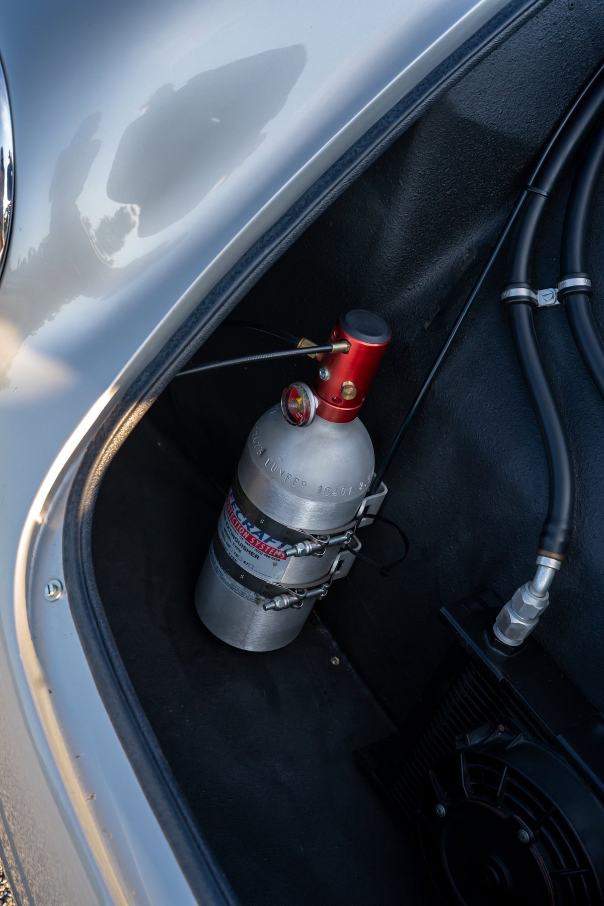 Closeup of a Nitrous Oxide Systems bottle in a silver Beck 550 Spyder trunk.