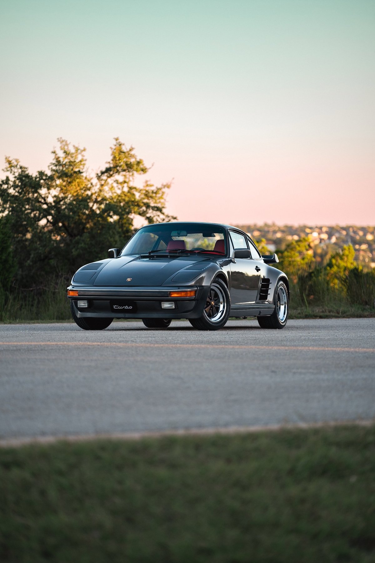 Slate grey metallic 1989 Porsche 930 Turbo Flachbau with red interior and Fuchs rims.