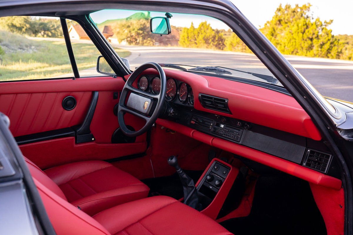 1989 Porsche 930 Turbo Flachbau interior with red leather trim and a black steering wheel.