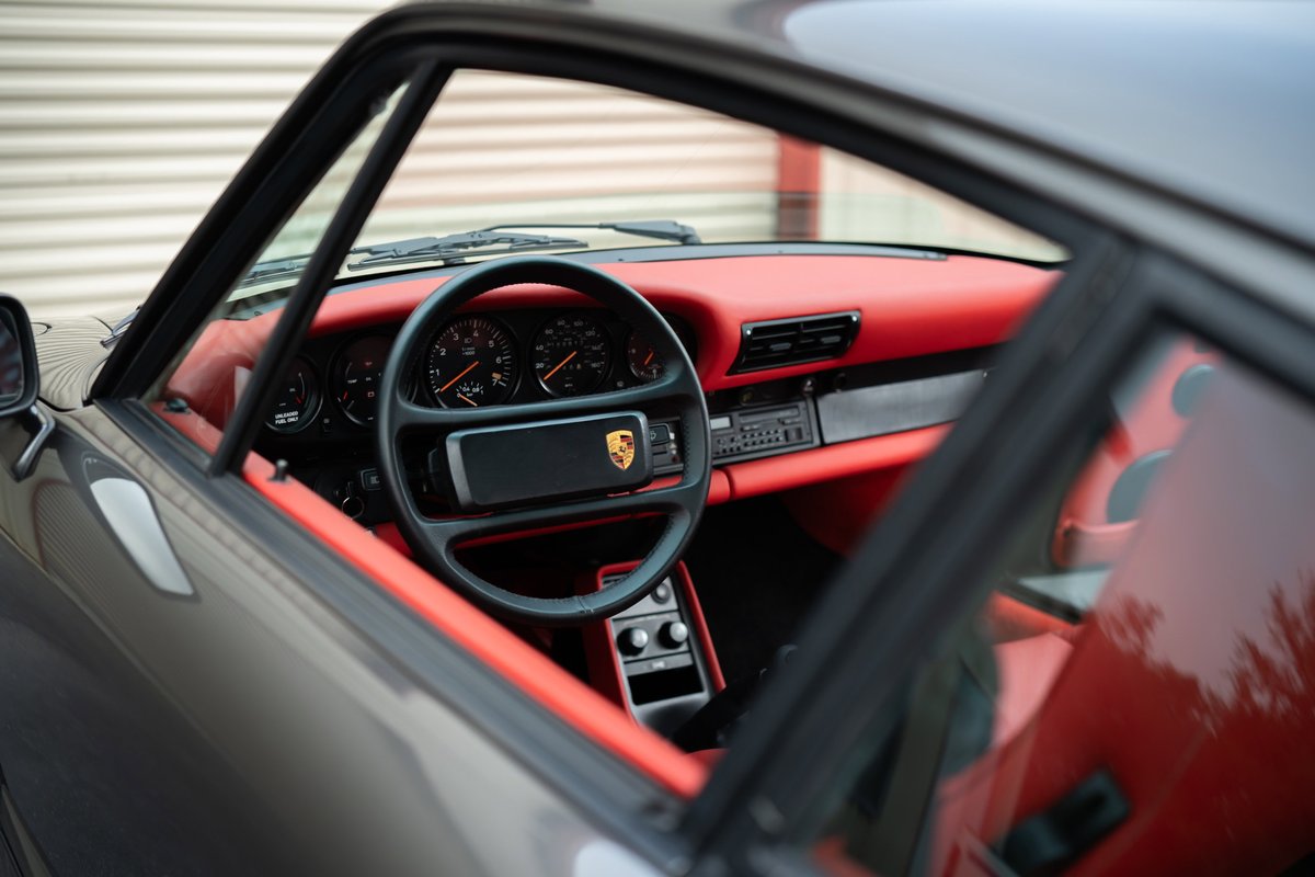 Interior of a slate grey 1989 Porsche 930 Turbo Flachbau with red leather trim and seats.