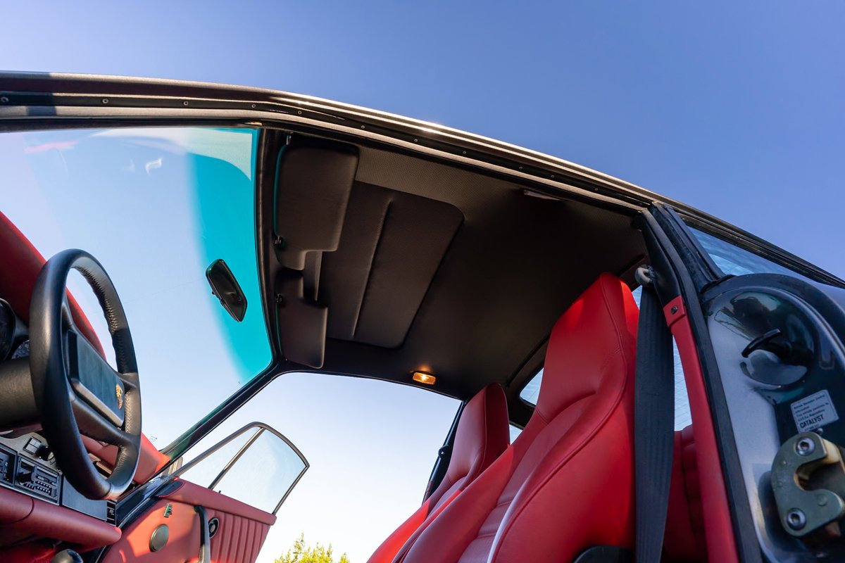 1989 Porsche 930 Turbo Flachbau interior with red leather seats, sunroof, and steering wheel.