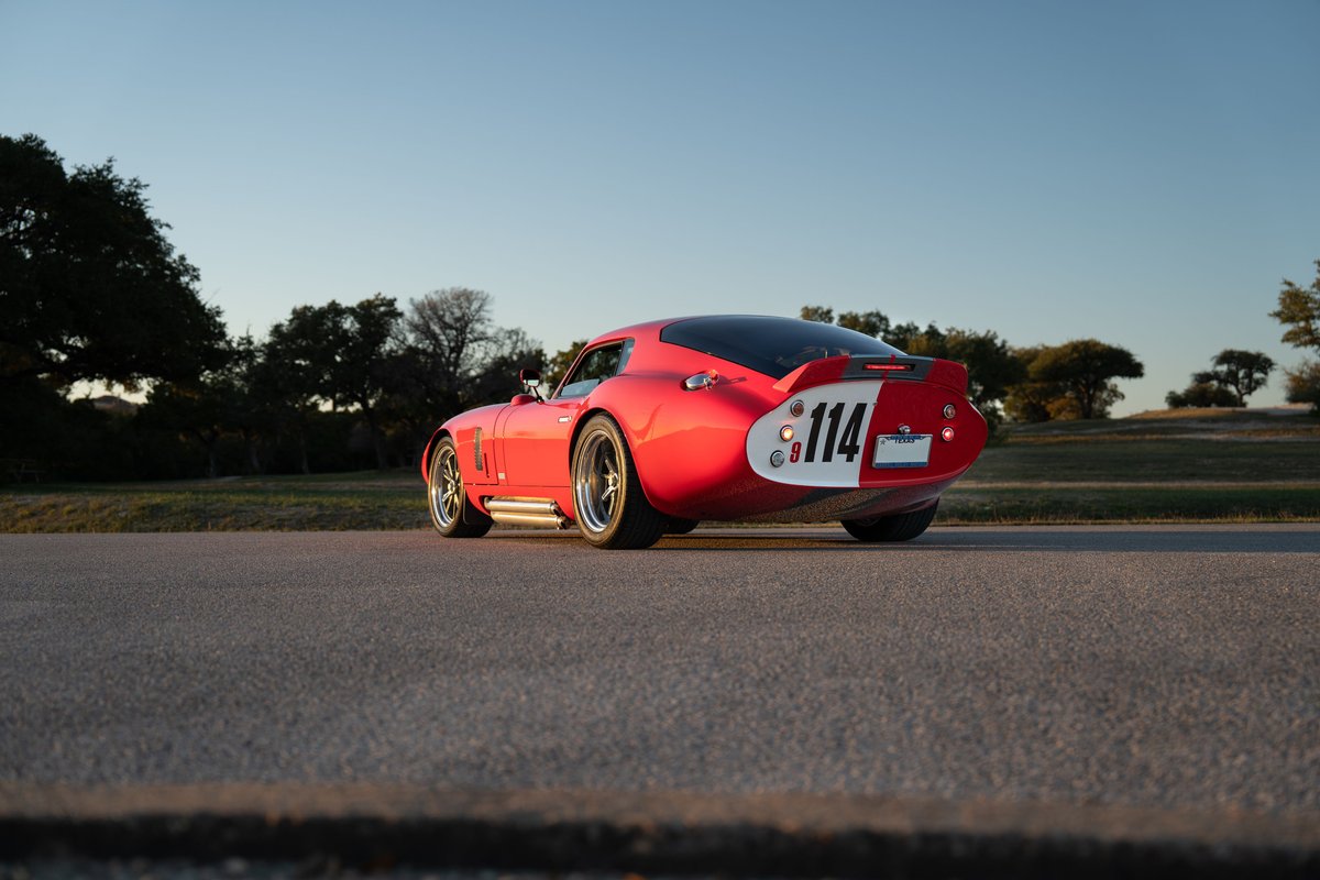 Red 1965 Superformance Shelby Daytona CSX with racing livery and custom rims.