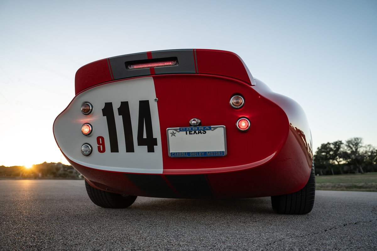 Rear view of a red 1965 Superformance Shelby Daytona with racing livery and number 114.