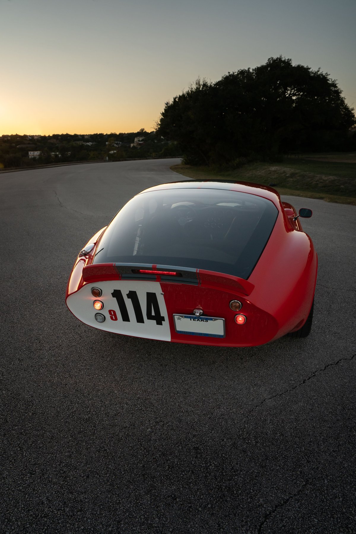 Red 1965 Superformance Shelby Daytona CSX coupe with racing livery and number 114.