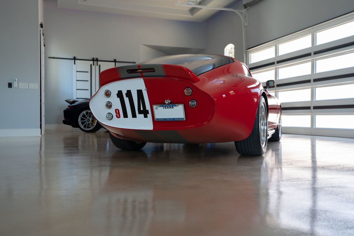 Red 1965 Superformance Shelby Daytona CSX coupe with white and grey racing livery and number 114.