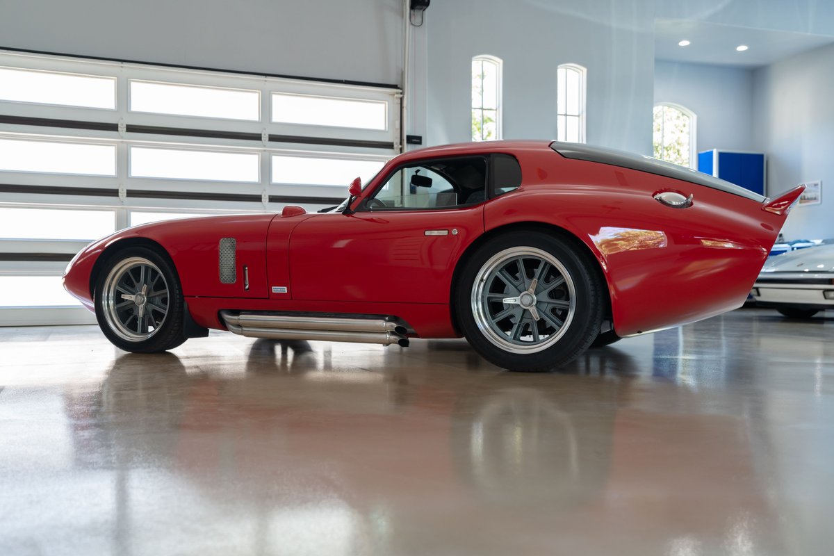 Monza Red 1965 Superformance Shelby Daytona Coupe with silver wire wheels and side exhaust.
