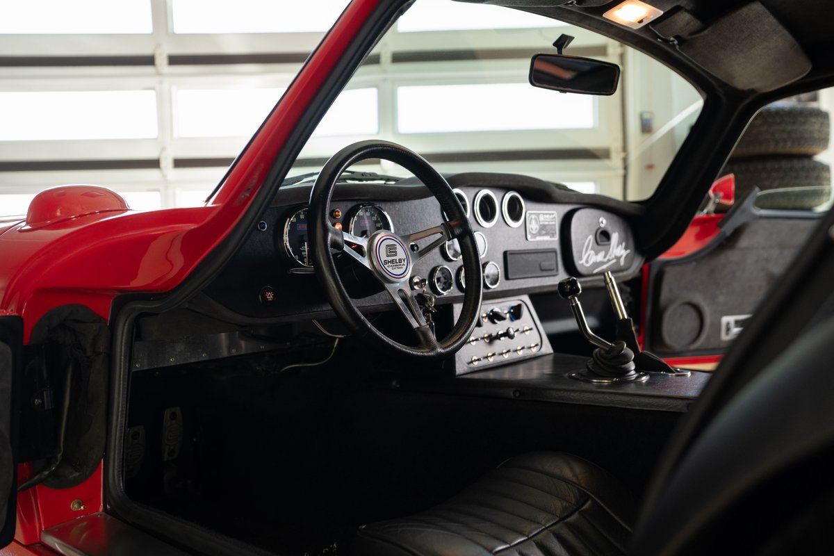 Red 1965 Superformance Shelby Daytona interior, with Shelby badging on the steering wheel.
