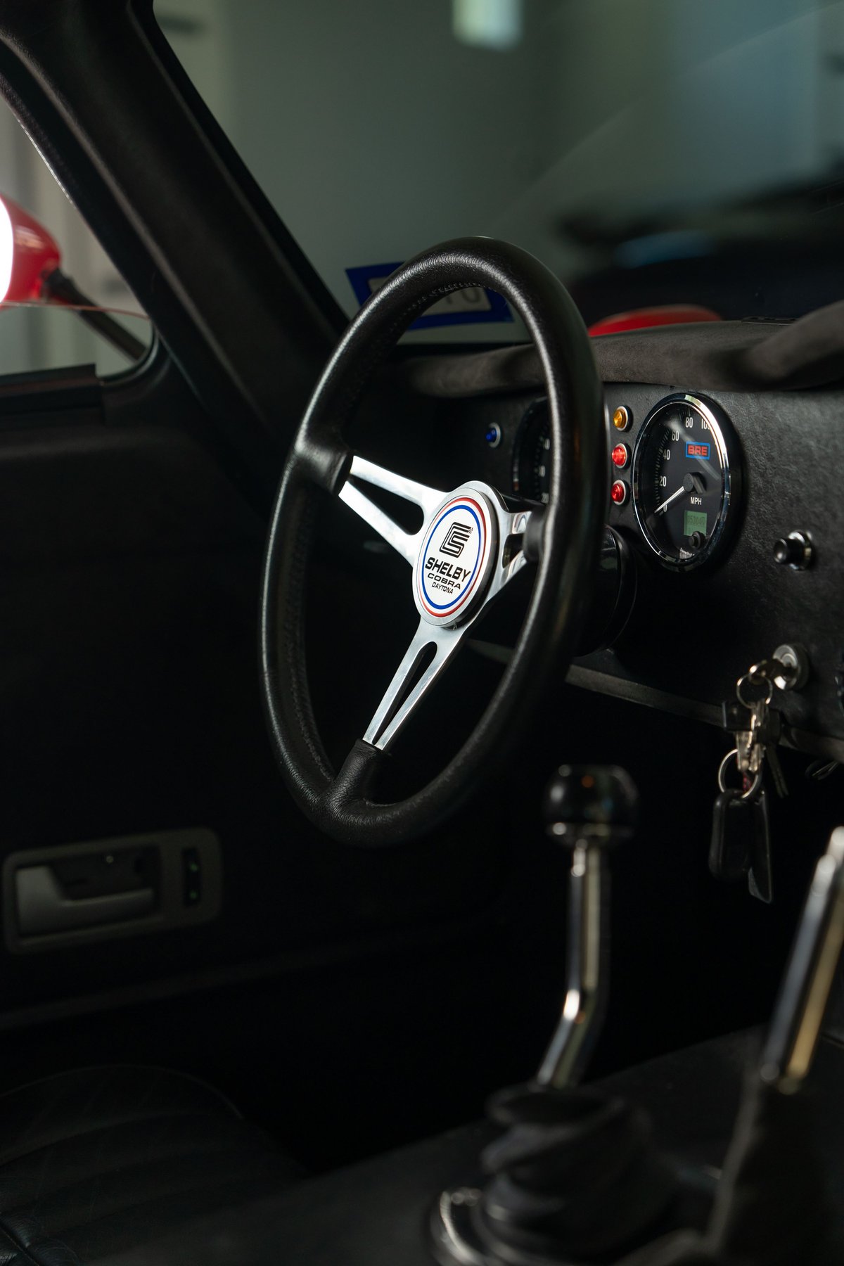 1965 Shelby Daytona Cobra CSX interior with Shelby steering wheel and chrome shifter.