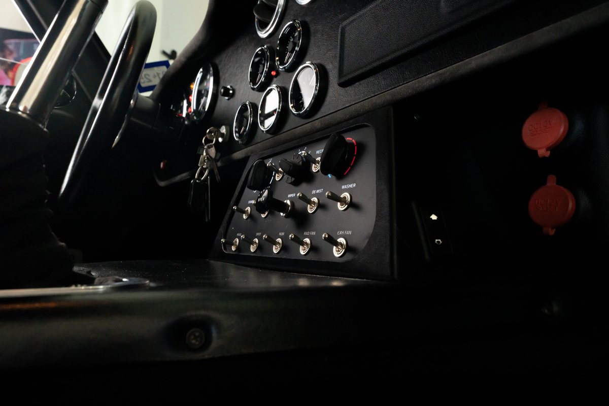 1965 Superformance Shelby Daytona in Monza Red: Close-up of the dashboard with toggles and gauges.