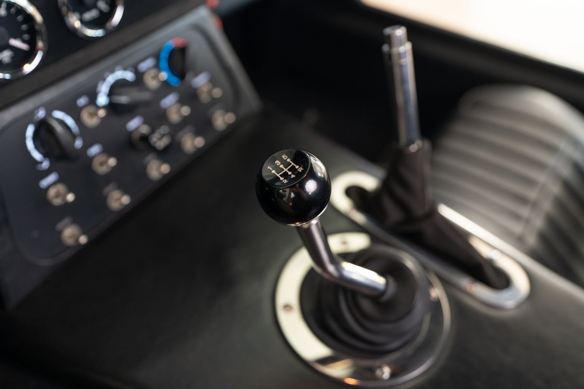 1965 Superformance Shelby Daytona CSX in Monza Red, interior view of the manual shifter and dash switches.