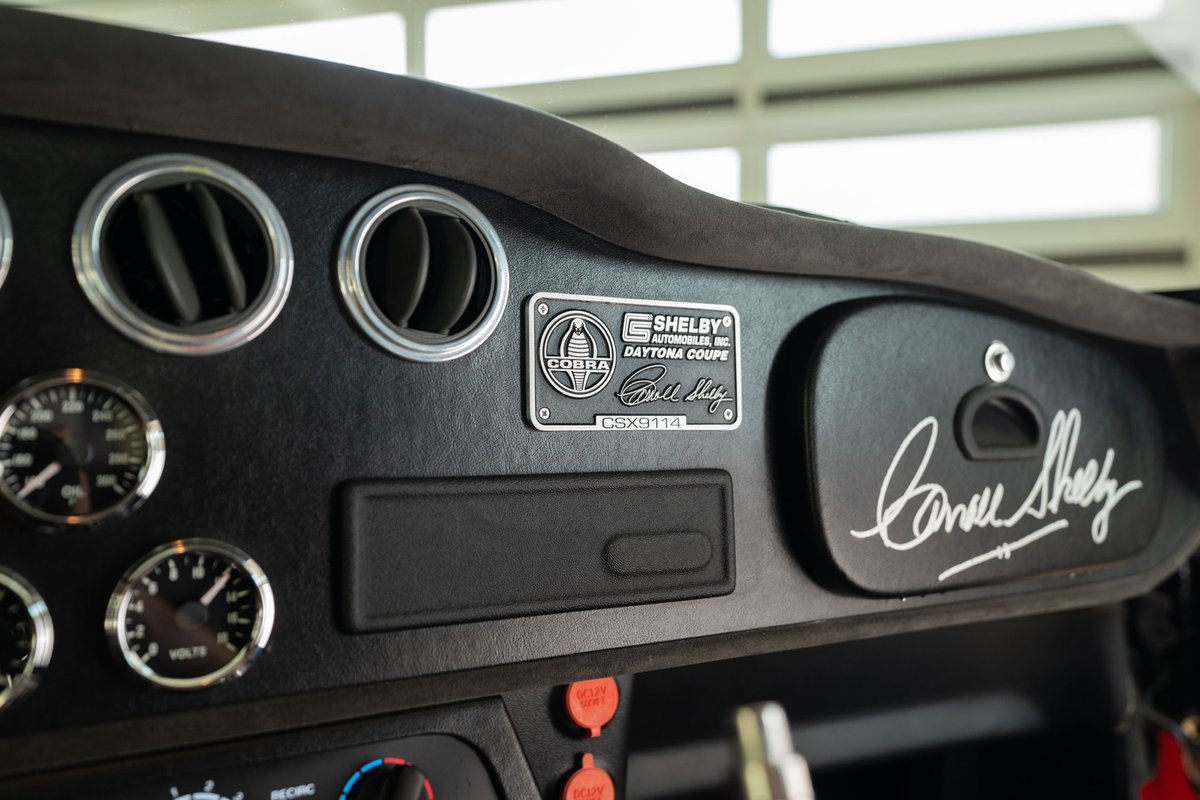 1965 Superformance Shelby Daytona Coupe dashboard, featuring Cobra badging and Carroll Shelby's signature.