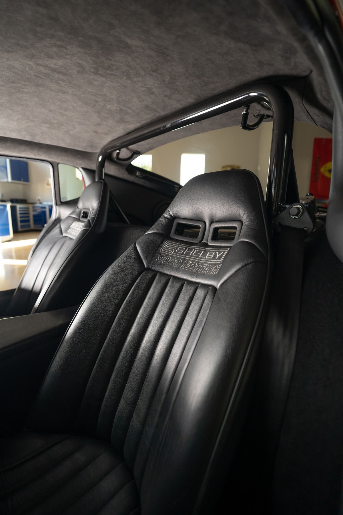 Close-up of black leather Shelby 3000 Edition seats with roll cage in a red 1965 Superformance Shelby Daytona.