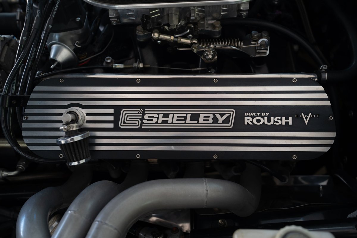 Close-up of a '65 Superformance Shelby Daytona CSX engine. Features Roush branding and V8 badging.