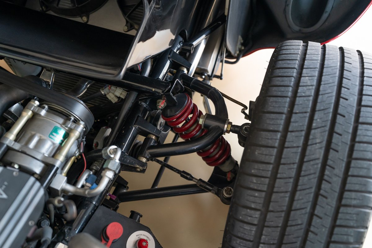Close-up of a red 1965 Superformance Shelby Daytona CSX tire and suspension system.