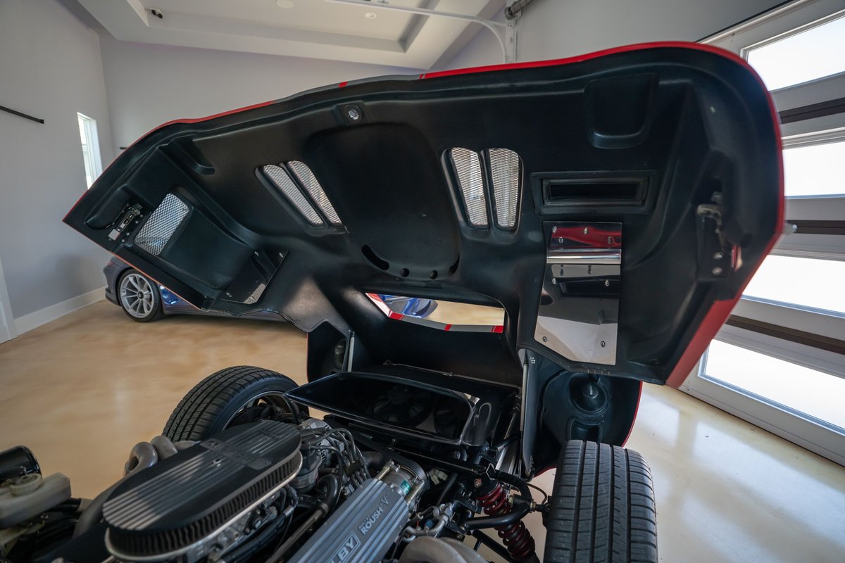 Monza Red Superformance Shelby Daytona CSX engine bay & open hood with red trim & carbon fiber accents.