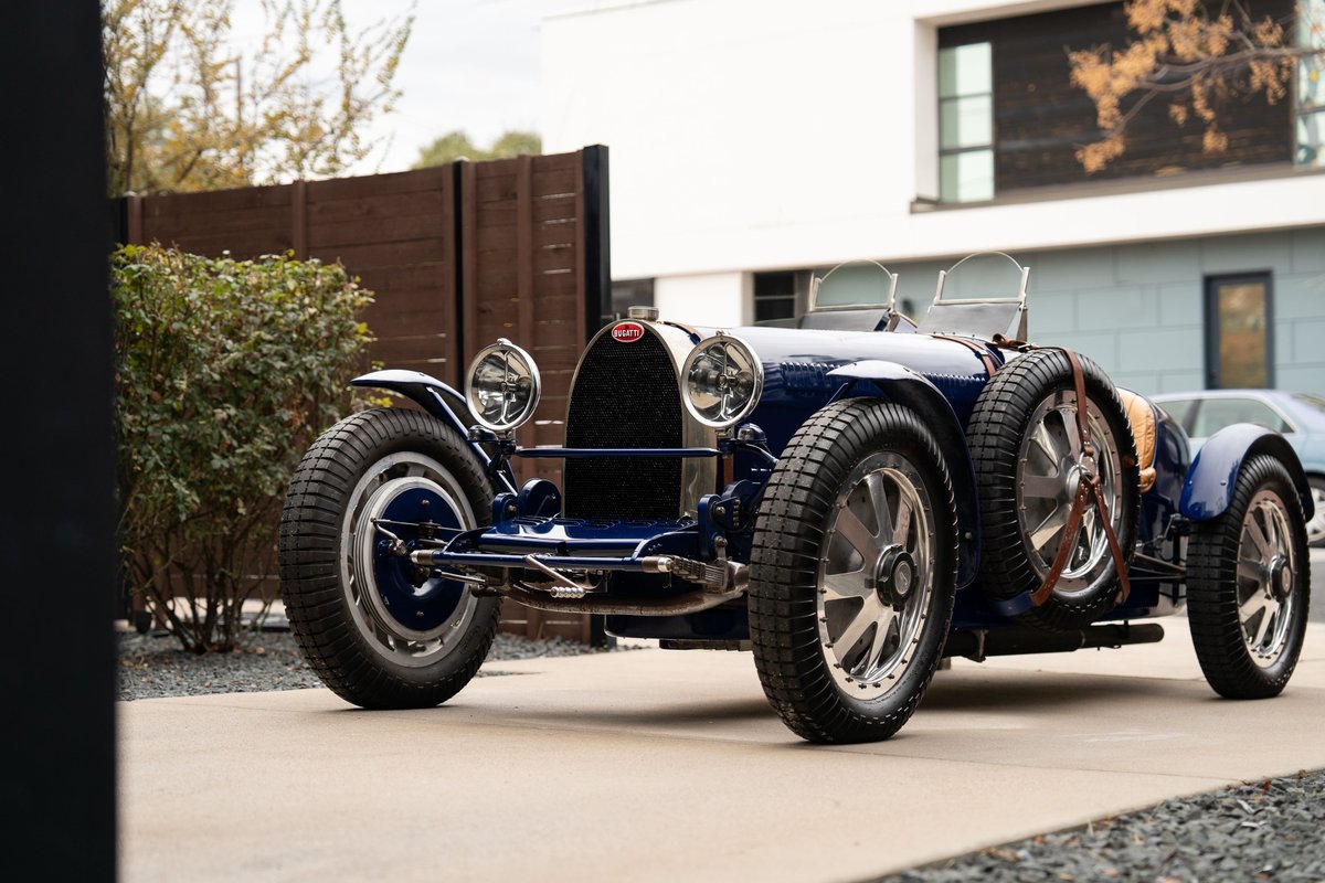 A blue 1927 Bugatti Type 35 Pur Sang with dual spare tires mounted on the side.