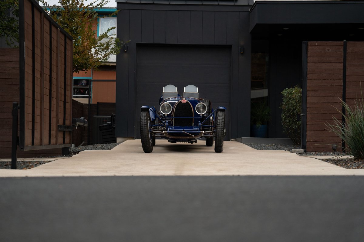 Front view of a dark blue 1927 Bugatti Type 35 Pur Sang with classic rims and chrome trim.