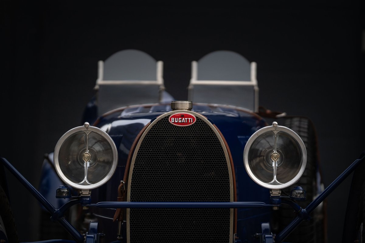 Close-up of the front of a blue 1927 Bugatti Type 35 Pur Sang. Features iconic grille and headlights.